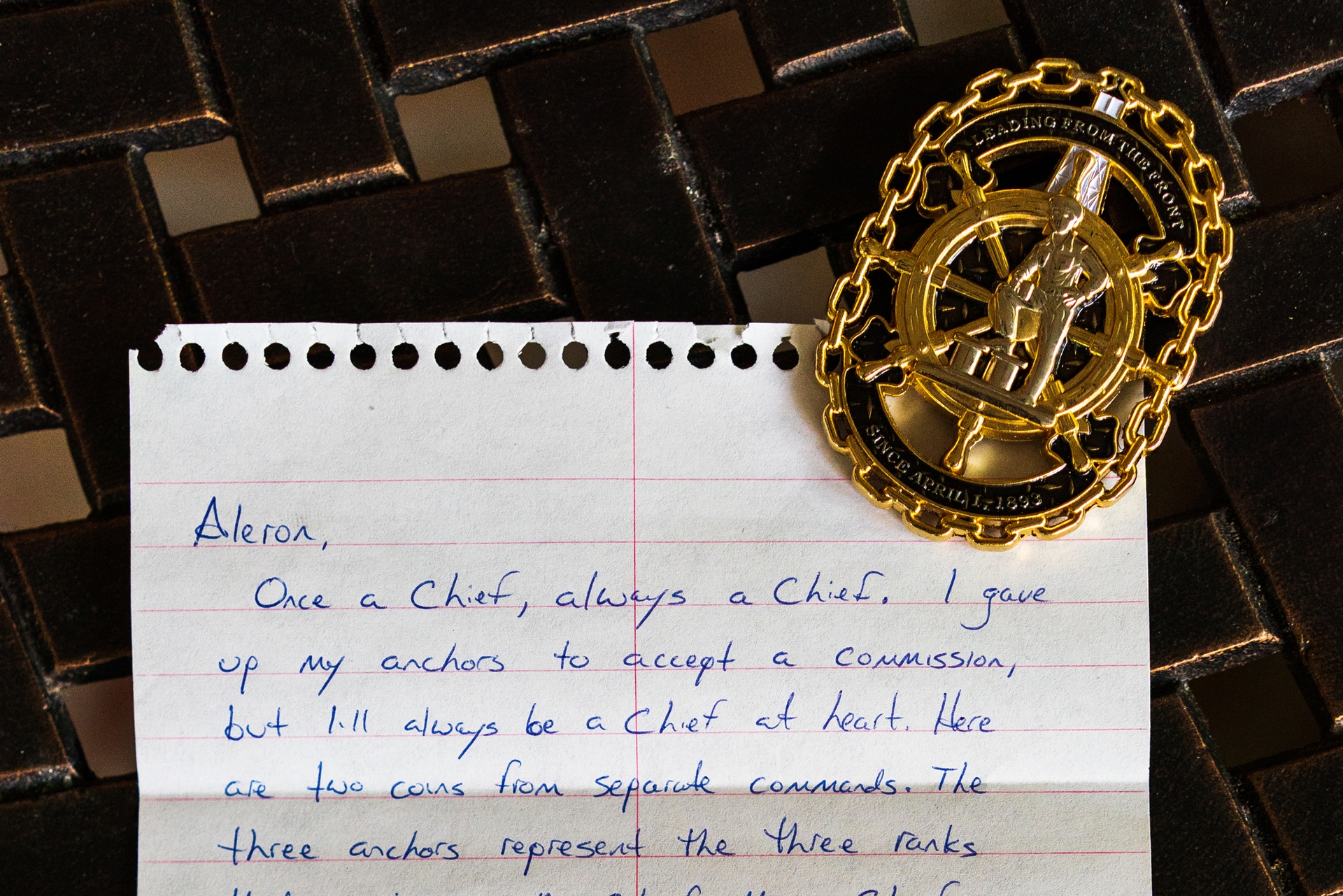 A handwritten fan letter to author Aleron Kong is shown with a military medal.