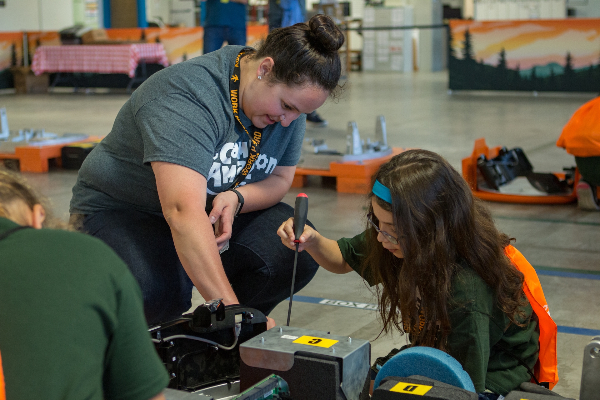 Teacher and student work on a robot during a Camp Amazon event